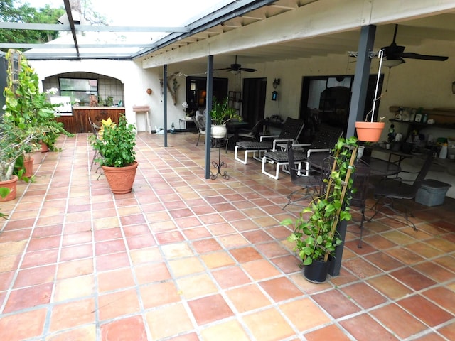 view of patio featuring a lanai and ceiling fan