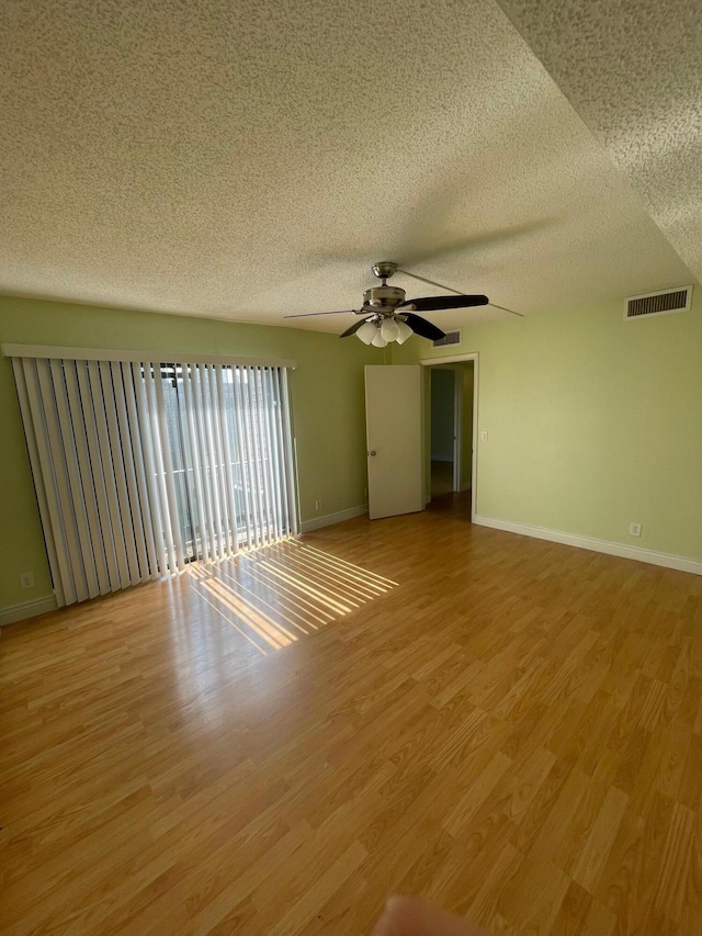 spare room with a textured ceiling, hardwood / wood-style floors, and ceiling fan