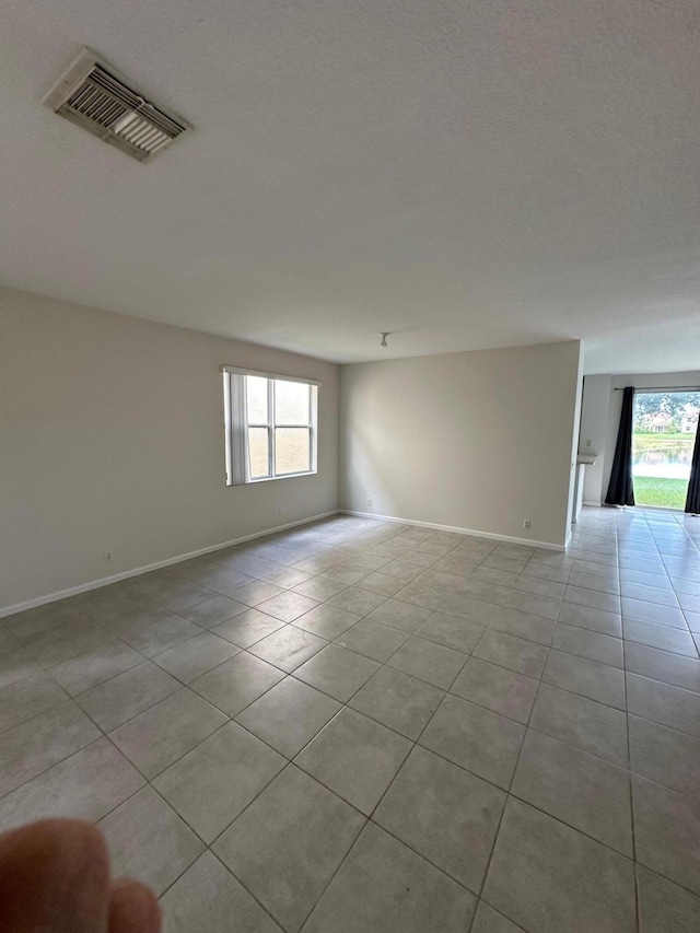 unfurnished room with a healthy amount of sunlight and light tile patterned floors