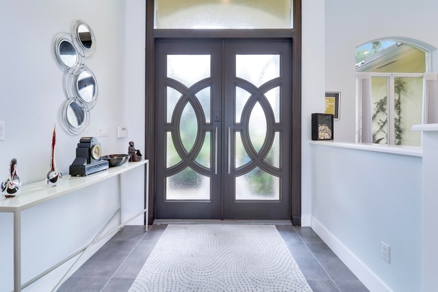 doorway to outside featuring french doors, a healthy amount of sunlight, and dark tile patterned floors