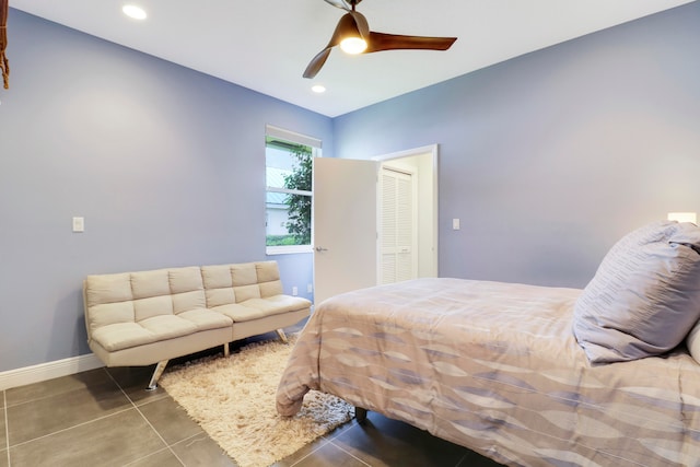 tiled bedroom featuring ceiling fan and a closet