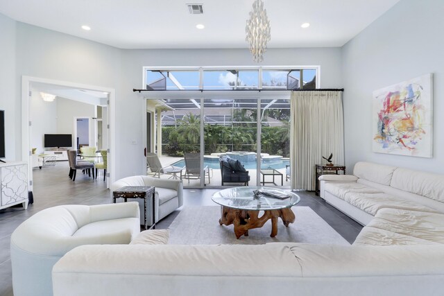 living room with french doors, a chandelier, and dark tile patterned floors