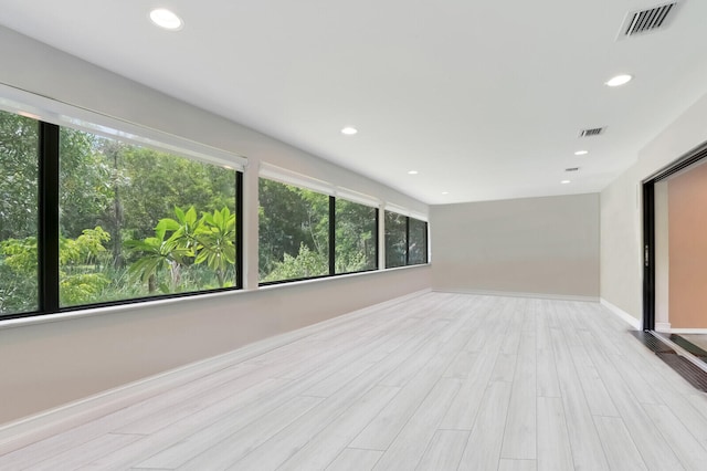 unfurnished room featuring light wood-type flooring and plenty of natural light