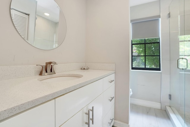 bathroom with walk in shower, toilet, hardwood / wood-style flooring, and vanity