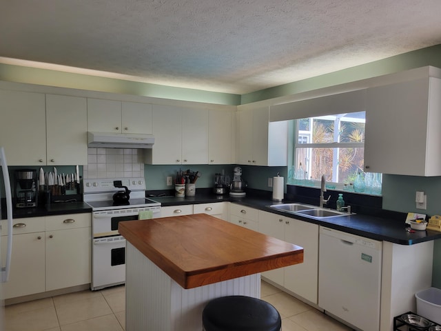 kitchen featuring sink, a kitchen island, light tile patterned flooring, white appliances, and white cabinets