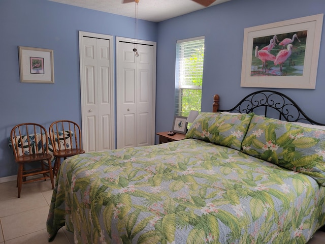 tiled bedroom featuring multiple closets