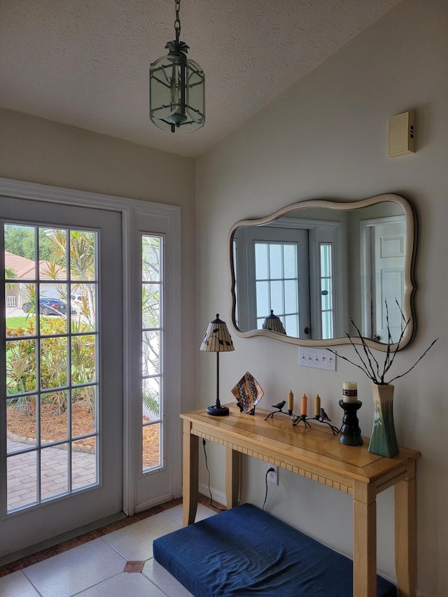 doorway featuring light tile patterned floors and a textured ceiling