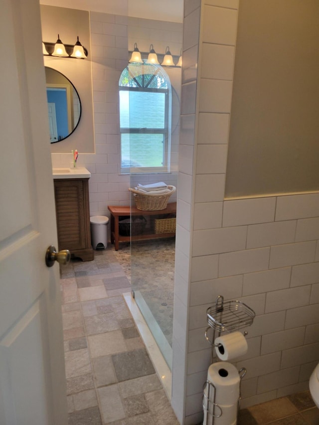 bathroom featuring vanity and tile walls