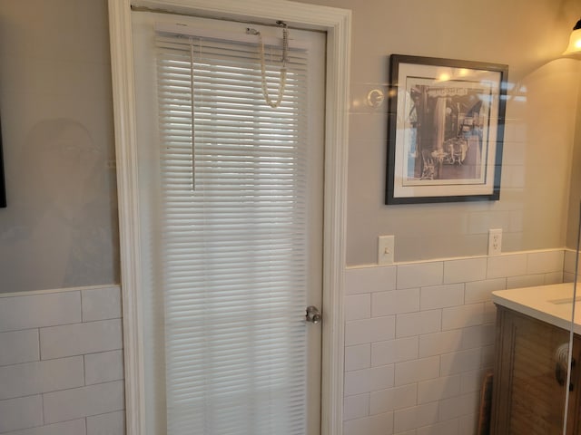 bathroom featuring vanity and tile walls