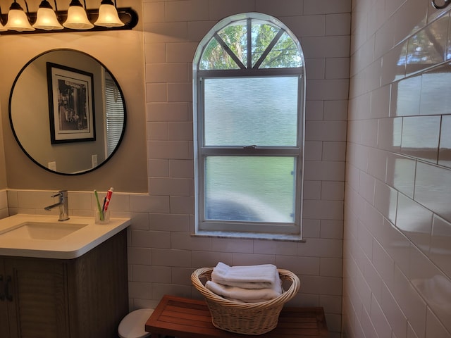 bathroom with vanity and tile walls