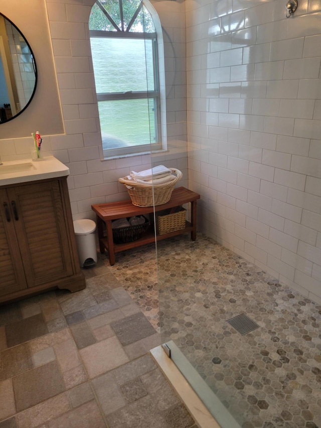 bathroom with vanity, tile walls, and walk in shower