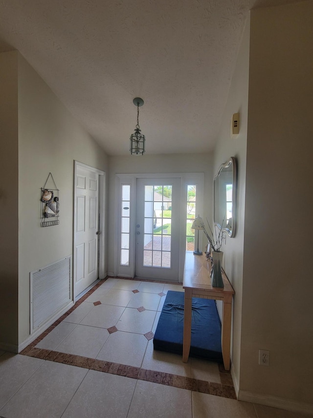 doorway to outside featuring light tile patterned floors, a textured ceiling, and vaulted ceiling