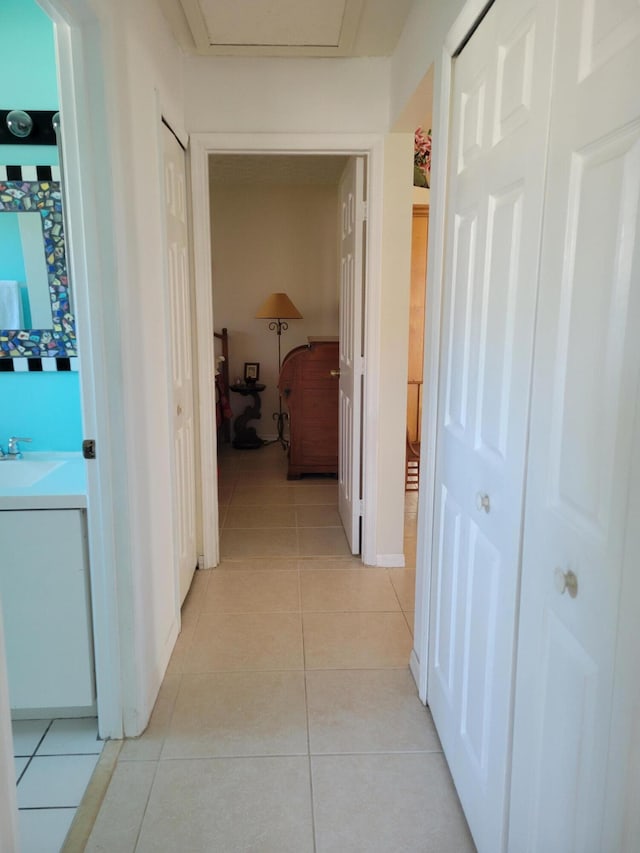 corridor with light tile patterned floors and sink