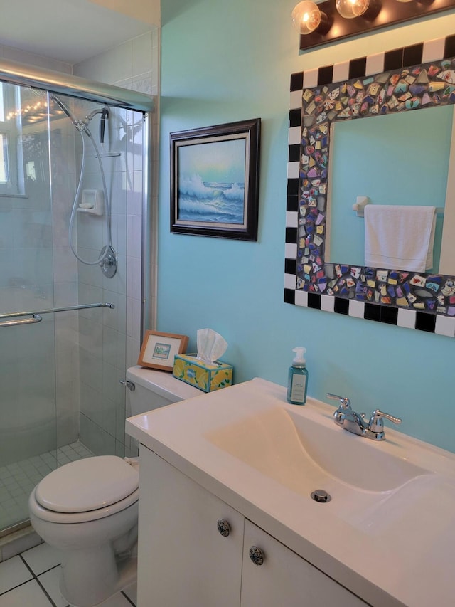 bathroom featuring tile patterned floors, vanity, toilet, and a shower with door