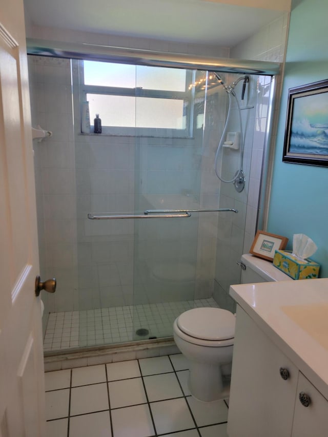 bathroom with tile patterned flooring, vanity, toilet, and an enclosed shower