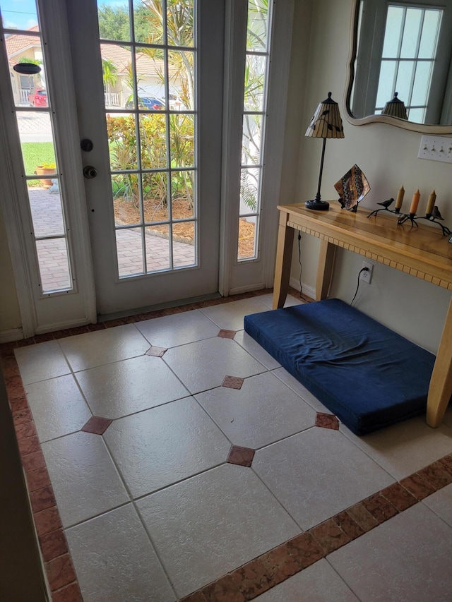 doorway to outside with a wealth of natural light and light tile patterned floors