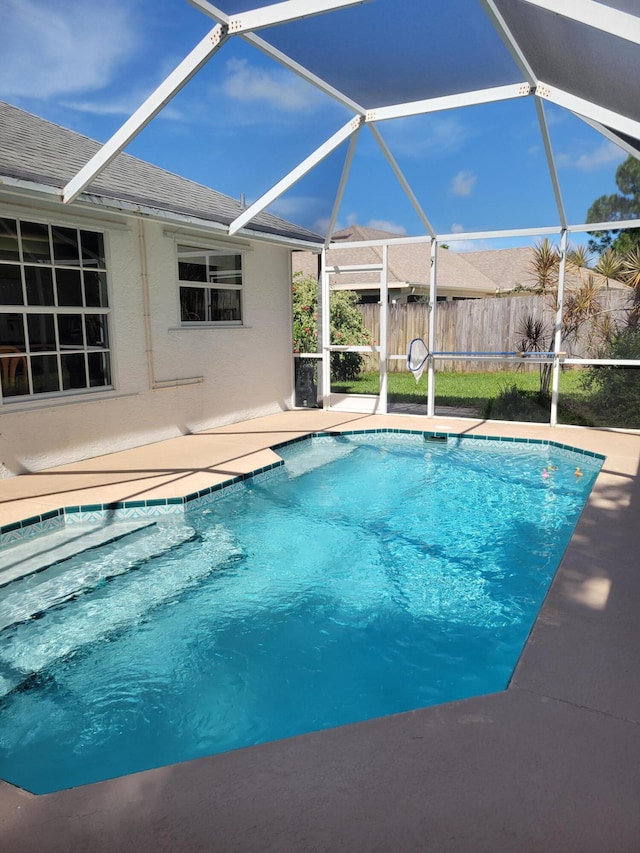 view of swimming pool featuring glass enclosure