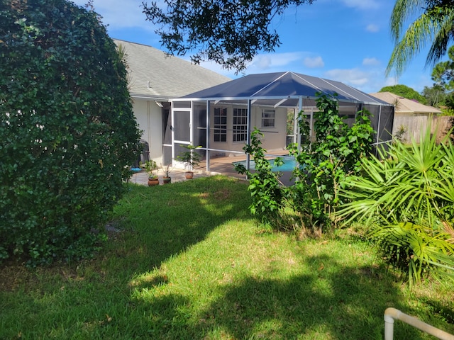 back of property featuring a lawn, glass enclosure, and a swimming pool