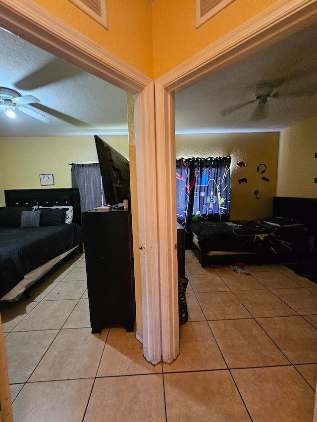 hallway with a textured ceiling and tile patterned floors