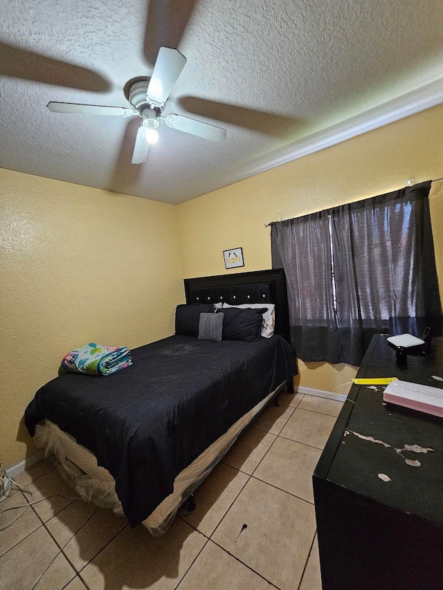 tiled bedroom featuring a textured ceiling and ceiling fan