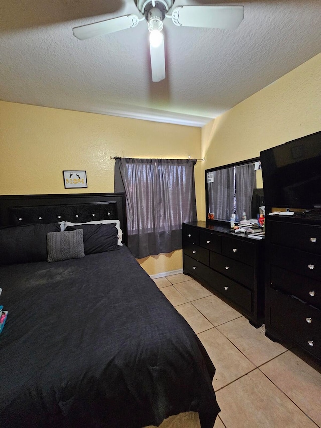 bedroom featuring a textured ceiling, light tile patterned flooring, and ceiling fan