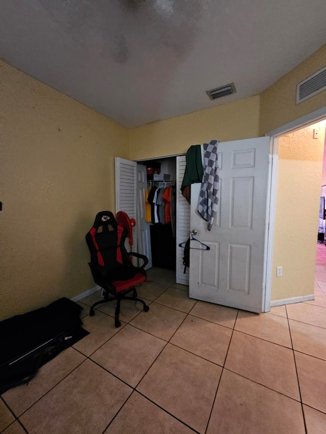 unfurnished bedroom with a closet and light tile patterned floors