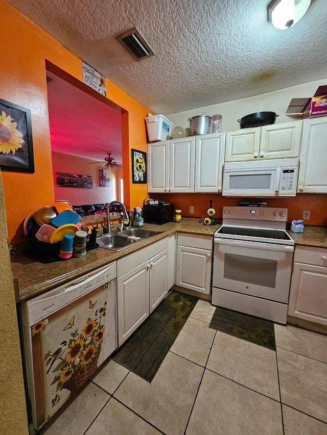 kitchen with light tile patterned floors, white appliances, white cabinetry, sink, and a textured ceiling