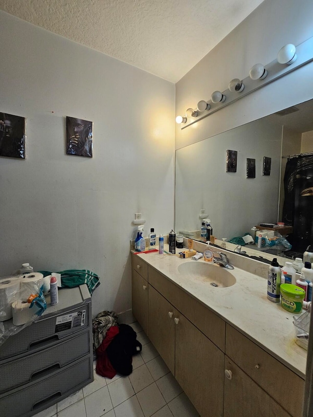 bathroom with vanity, a textured ceiling, and tile patterned flooring