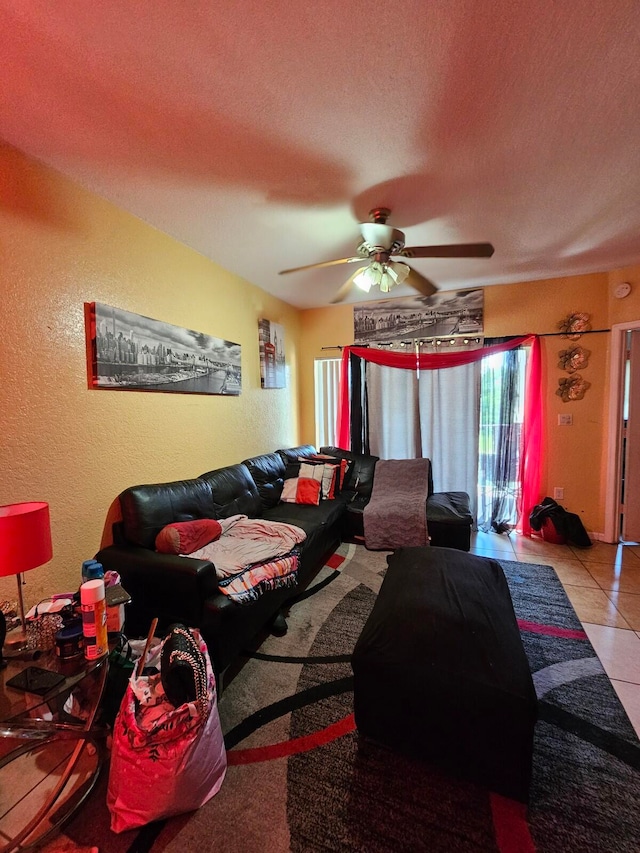 living room featuring ceiling fan, light tile patterned floors, and a textured ceiling