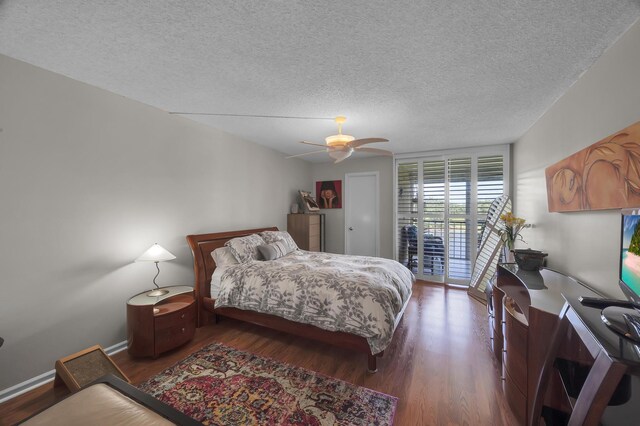 bedroom with a textured ceiling, ceiling fan, dark hardwood / wood-style flooring, and access to outside