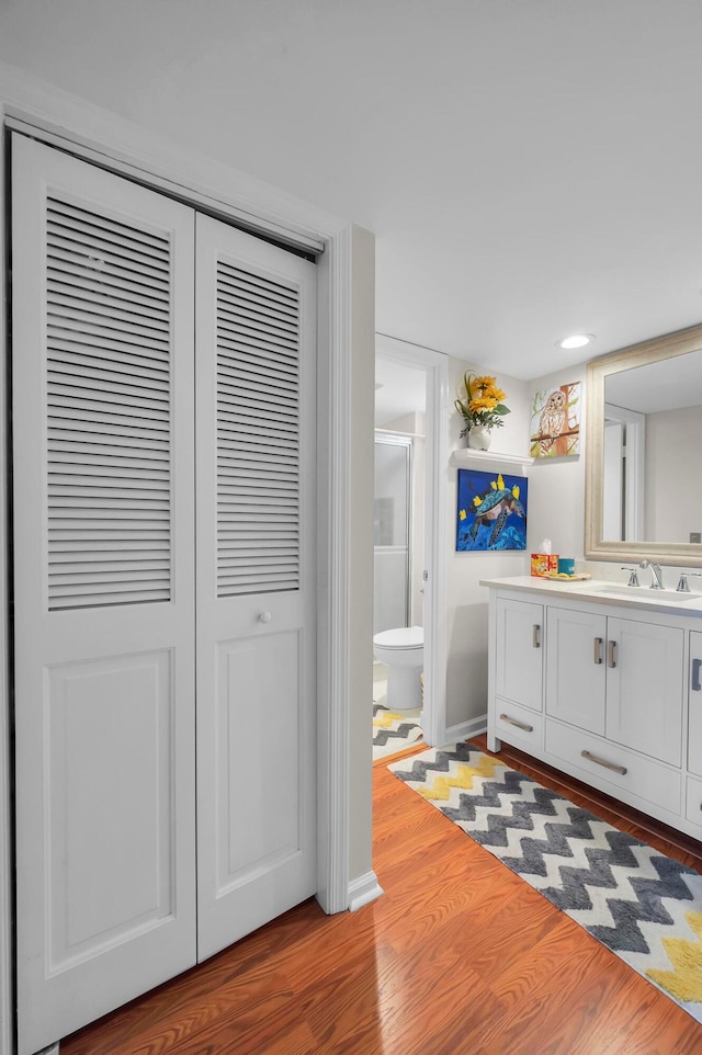 bathroom featuring vanity, toilet, and hardwood / wood-style floors