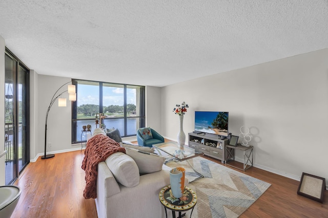 living area with a wall of windows, wood finished floors, and baseboards