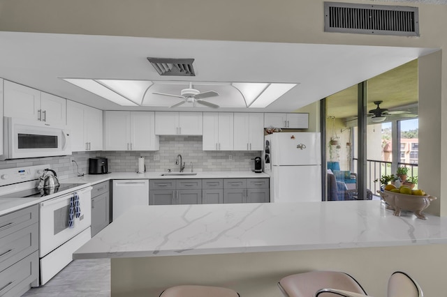 kitchen with gray cabinets, white appliances, and ceiling fan