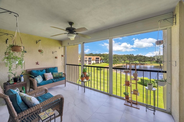 sunroom / solarium featuring a water view and ceiling fan