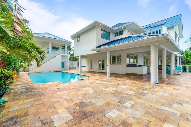 back of house featuring a fenced in pool and a patio