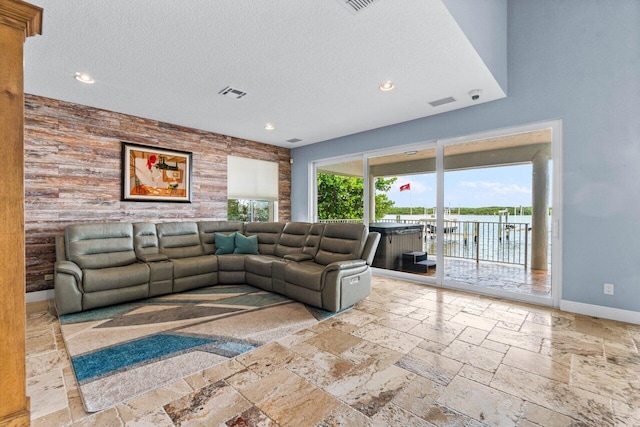 living room with a textured ceiling and a water view