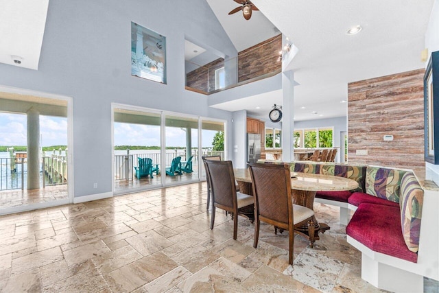 dining space featuring ceiling fan and high vaulted ceiling