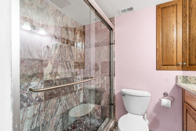 bathroom featuring a shower with door, a textured ceiling, toilet, and vanity