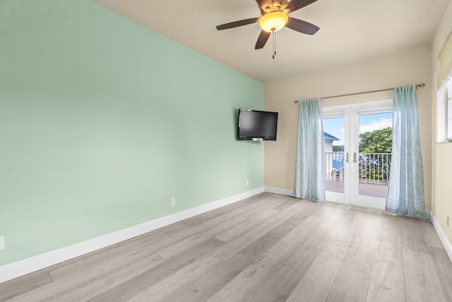 empty room with ceiling fan, light hardwood / wood-style floors, and french doors