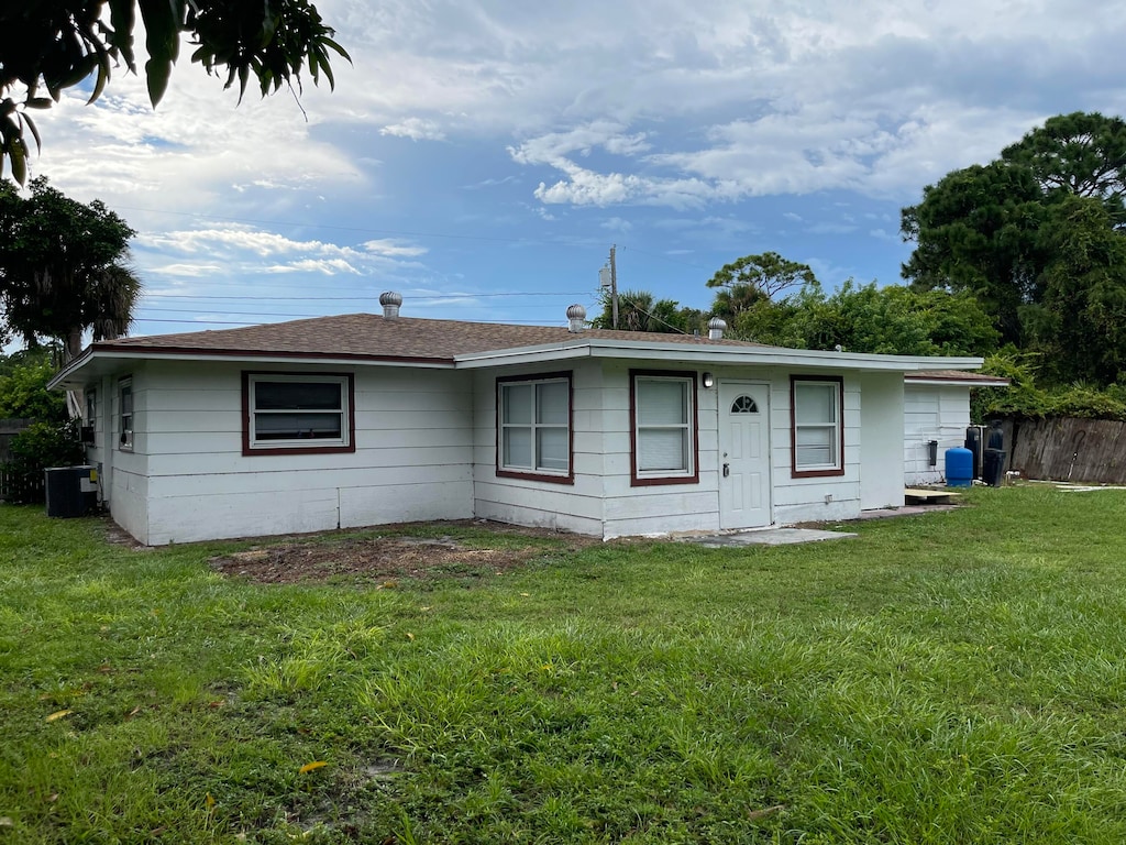 single story home with a front lawn and central air condition unit