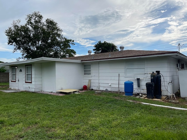 back of house featuring a lawn