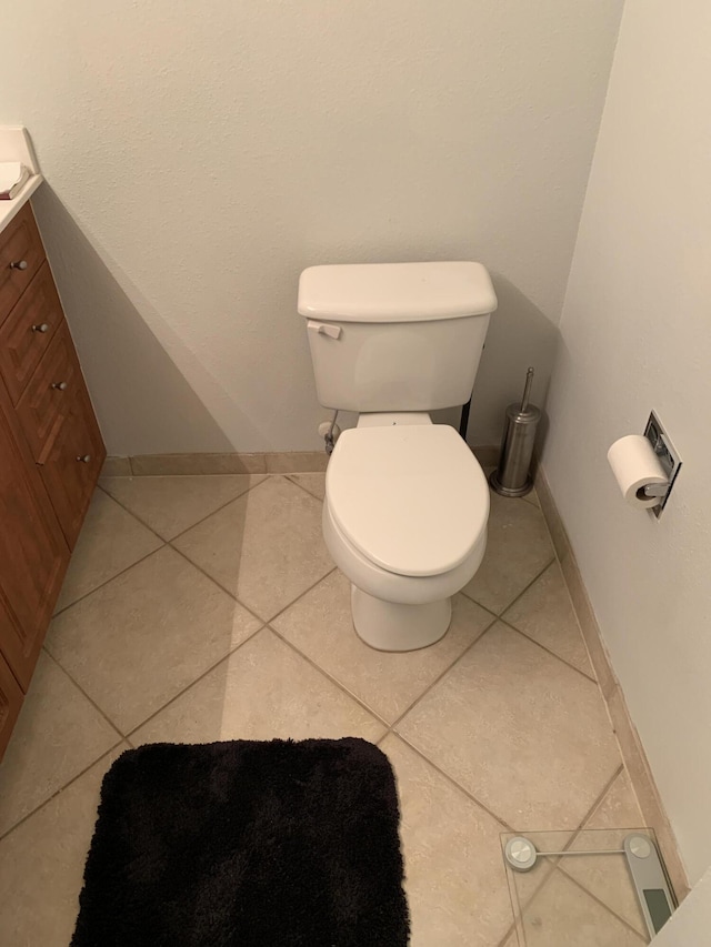 bathroom featuring tile patterned floors, baseboards, toilet, and vanity