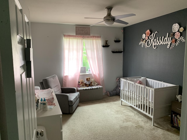 bedroom with a crib, carpet, and ceiling fan