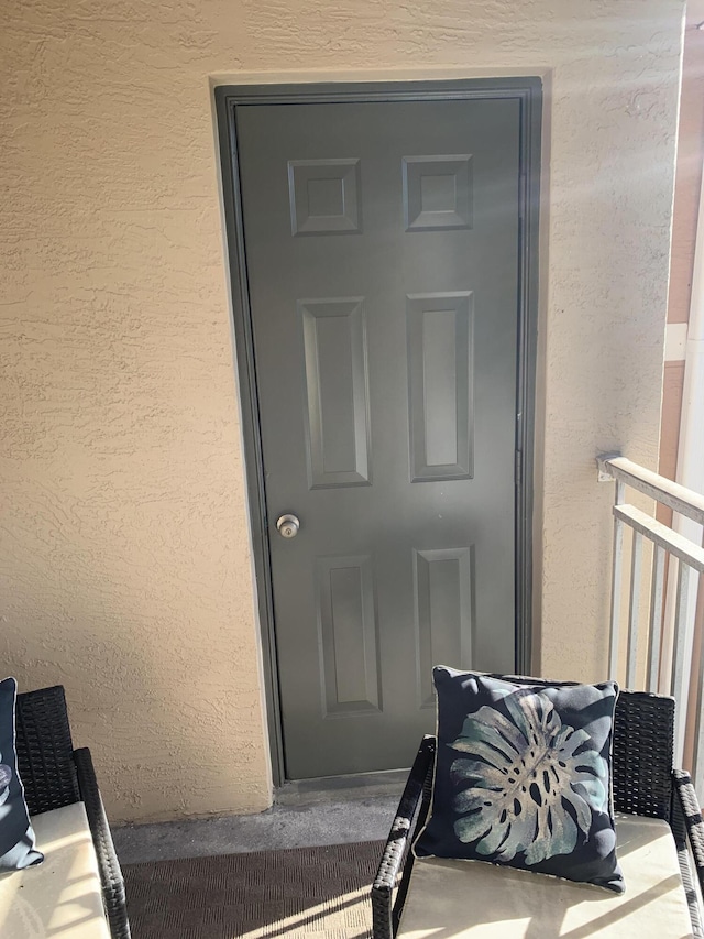 property entrance with stucco siding