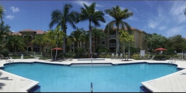 community pool featuring a patio and fence