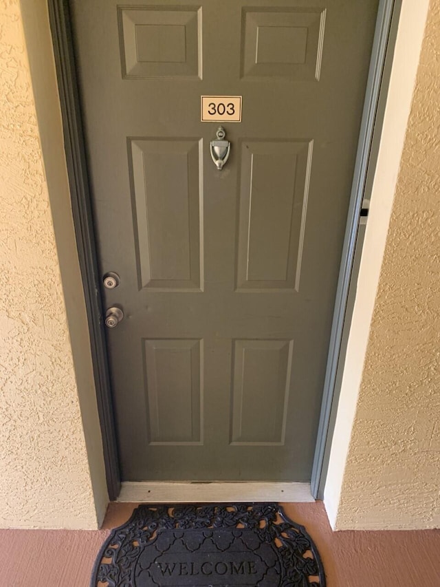 view of exterior entry featuring stucco siding