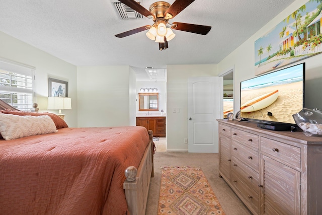 411 Sandpiper Dr Unit A, Fort Pierce, FL 34950 - bedroom with visible vents, a ceiling fan, light colored carpet, ensuite bathroom, and a textured ceiling
