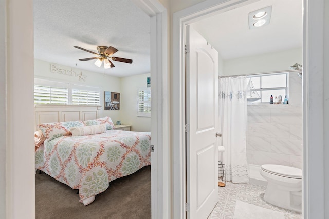 carpeted bedroom featuring tile walls, ceiling fan, and a textured ceiling