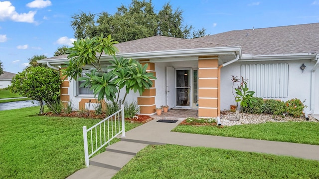 411 Sandpiper Dr Unit A, Fort Pierce, FL 34950 - view of front of property featuring a shingled roof, a front lawn, and stucco siding