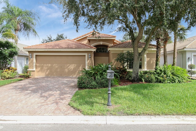 mediterranean / spanish-style home with a garage and a front lawn